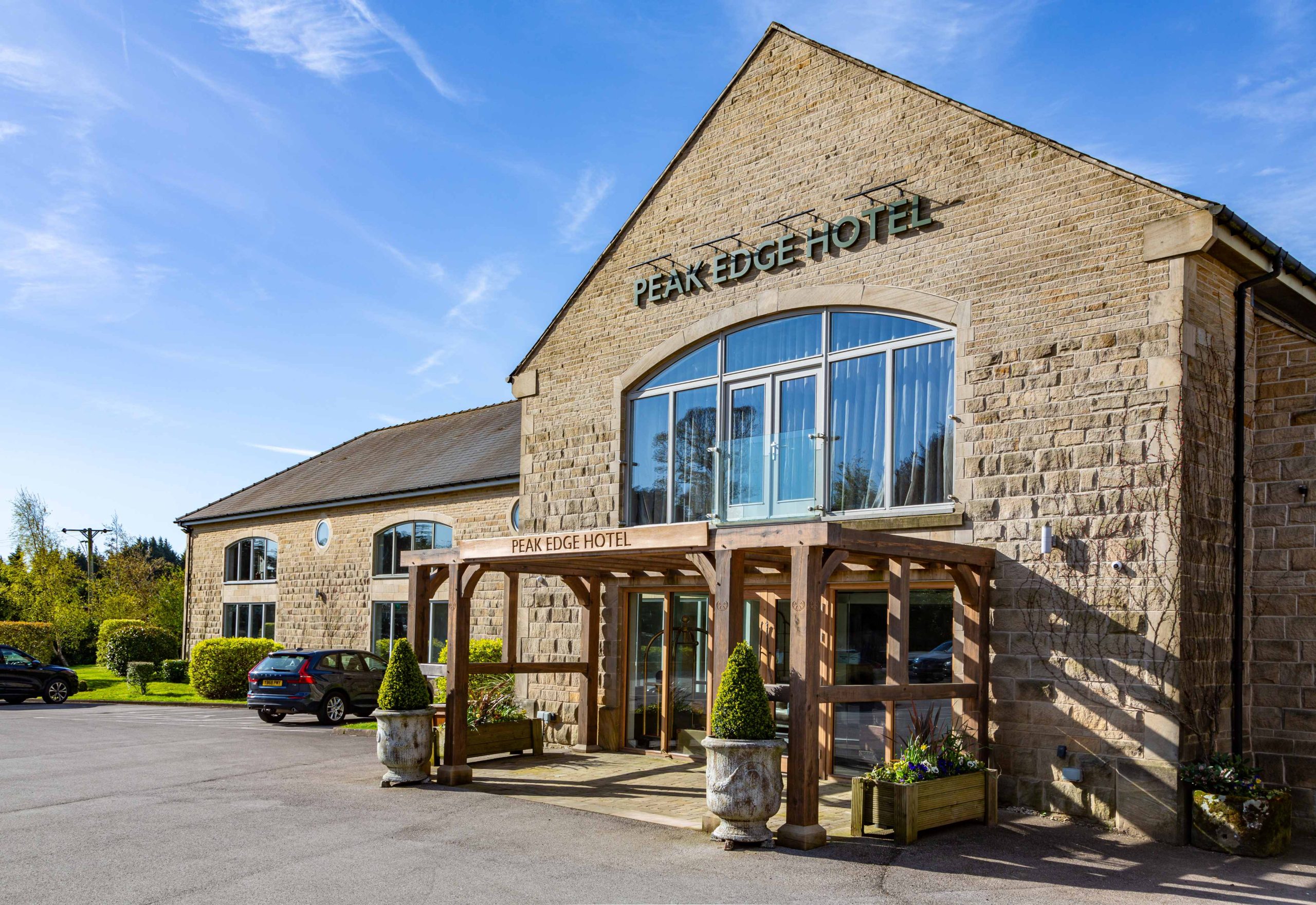 the exterior facade of peak edge hotel, featuring a wooden pagola sructure