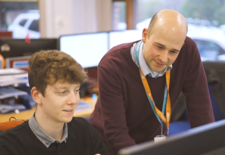 Young man and his mentor looking at a computer screen
