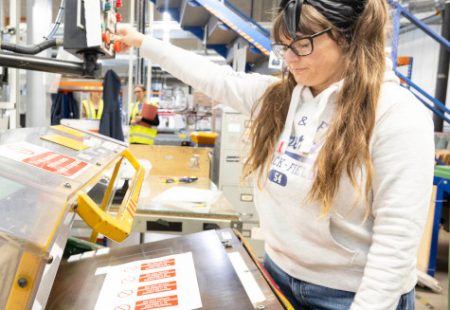 Female team member creating labels in the factory at MTM Products, Chesterfield