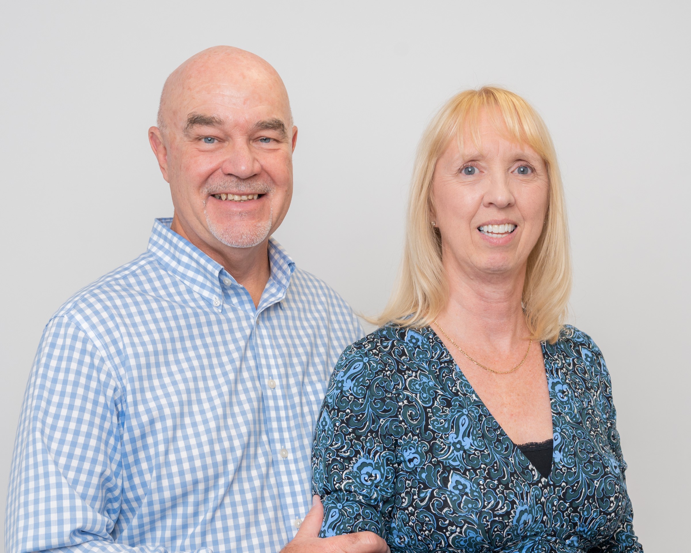 1 male and 1 female smiling at the camera
