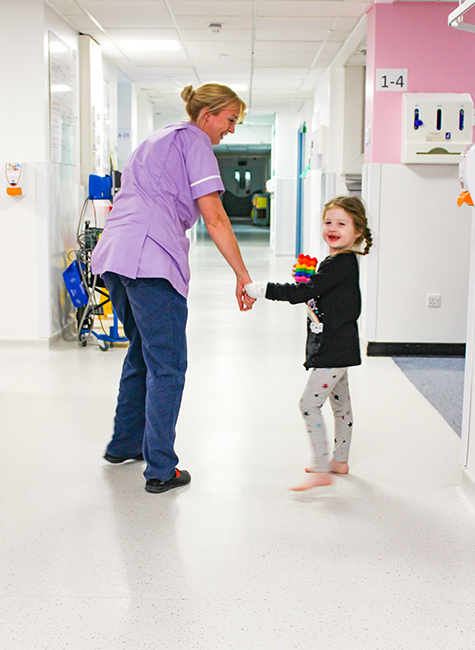 1 female healthcare professional and a young girl on a childrens hospital ward
