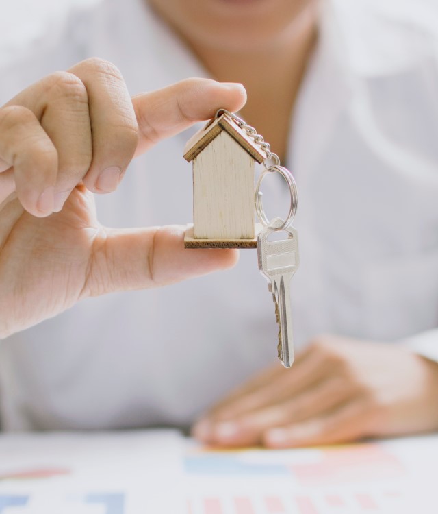 Man holding keyring with house model