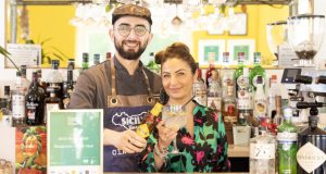 Owners of Sicily Restaurant at their fully stocked bar, drinks in hands