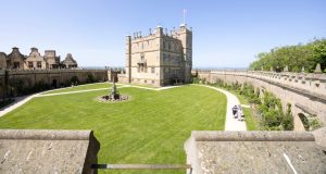 Bolsover Castle and castle wall in front, lots of freshly cut grass in the middle