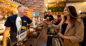 Head brewer serving ale to a female at the brewery bar