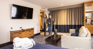 Male and female walking into hotel room at Casa Hotel female receptionist