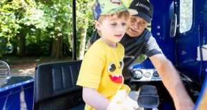 Male driver of Puffin Billy at showing young boy the train controls