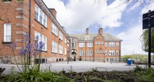 Back of red brick University of Derby building, purple flowers at front