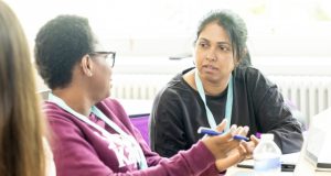 Two black student nurses in discussion during lesson at University of Derby