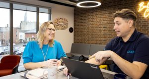 1 male and 1 female - business people speaking at table at Chesterfield Enterprise Centre, male sat with laptop
